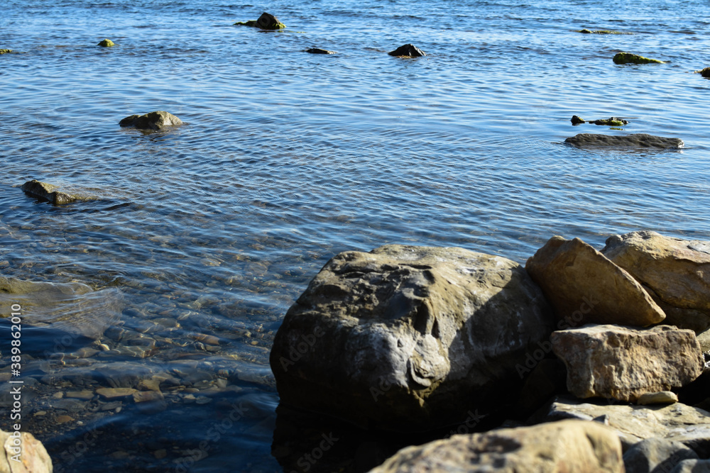 Rugged rocks against a deep blue sea. Travel or vacation background. Rugged rocks against a deep blue sea. Travel or vacation background.