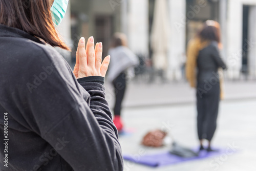 Yoga teachers protesting against the blockade and restrictions of Covid-19 in a square in Brescia, Italy. Female and male hands in a namaste or prayer gesture.