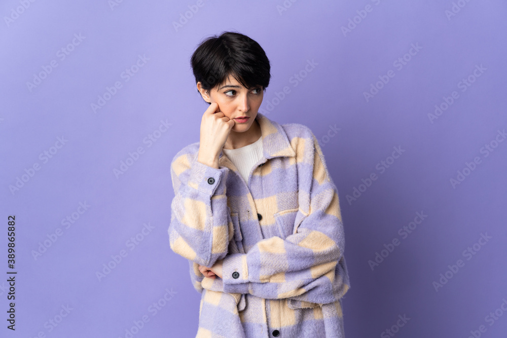 Woman with short hair isolated on purple background with tired and bored expression Woman with short hair isolated on purple background with tired and bored expression