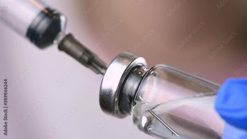 Nurse filling injection syringe from vial Nurse filling injection syringe from vial