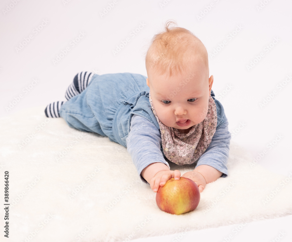 Portrait of a charming baby girl is playing with red apple Portrait of a charming baby girl is playing with red apple