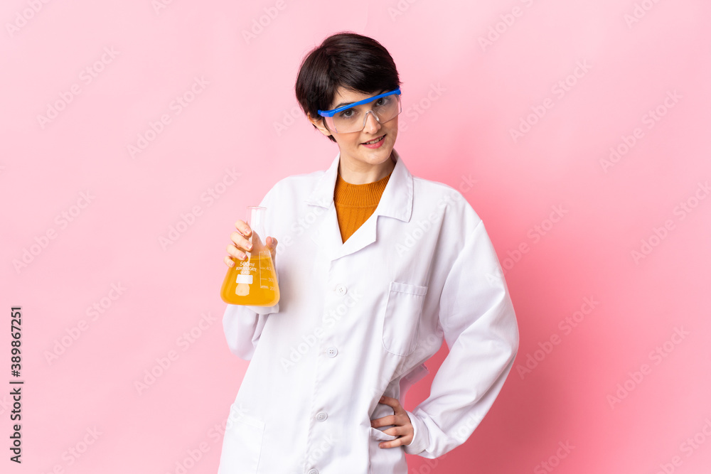 Young scientific woman isolated on pink background posing with arms at hip and smiling Young scientific woman isolated on pink background posing with arms at hip and smiling