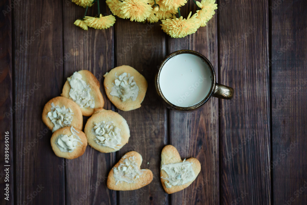 homemade cookies in nuts and a cup of milk on a wooden background. Valentine's Day. romantic atmosphere homemade cookies in nuts and a cup of milk on a wooden background. Valentine's Day. romantic atmosphere