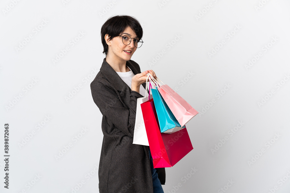 Woman with short hair isolated on white background holding shopping bags and smiling Woman with short hair isolated on white background holding shopping bags and smiling