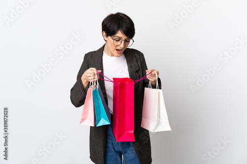 Woman with short hair isolated on white background holding shopping bags and looking inside it
