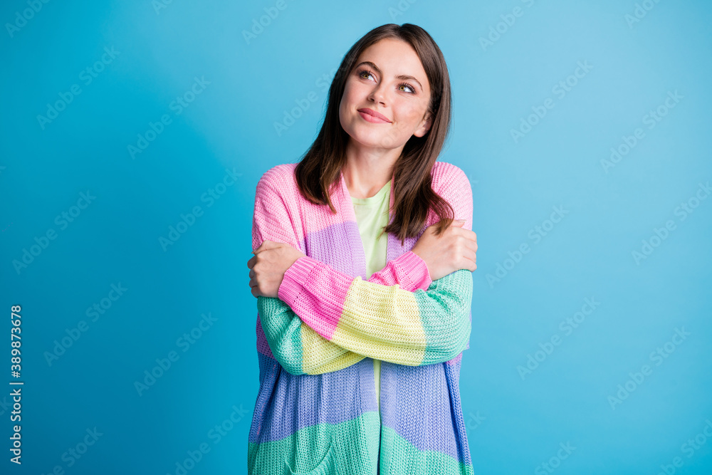 Photo of attractive happy dreamy young woman look empty space self hug isolated on blue color background Photo of attractive happy dreamy young woman look empty space self hug isolated on blue color background