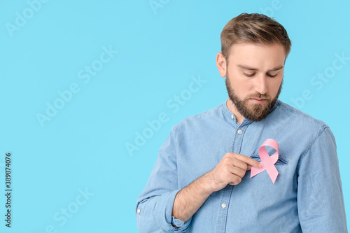 Man with pink ribbon on col...