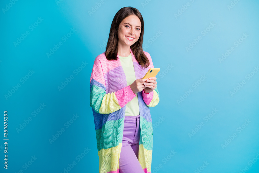 Photo of joyful brown haired woman hold hands phone follow blog isolated on shine blue color background Photo of joyful brown haired woman hold hands phone follow blog isolated on shine blue color background