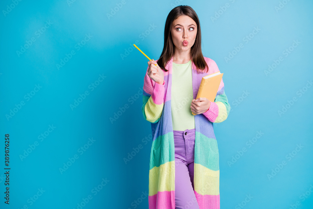 Photo of pretty creative girl wonder write diary wear purple trousers look point empty space isolated on blue color background