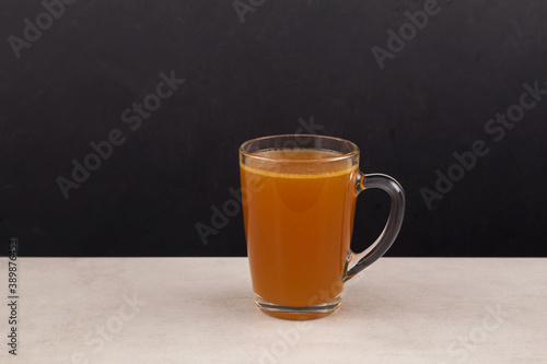Homemade beef bone broth with natural collagen. Bouillon in transparent mug. Selective focus, copy space