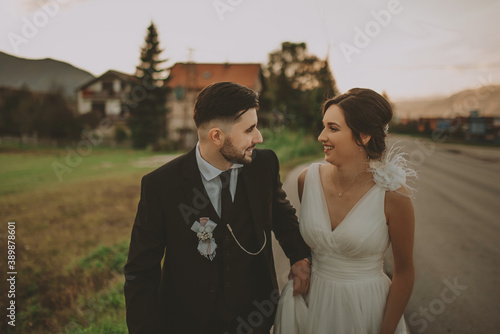 Bride and groom in a park kissing.couple newlyweds bride and groom at a wedding in nature green forest are kissing photo portrait.Wedding Couple © Minet