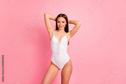 Portrait of her she nice-looking attractive lovely gorgeous winsome confident sportive cheerful cheery straight-haired lady in one-piece suit isolated over pink pastel background