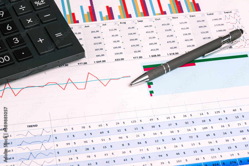 Financial business charts and table with company income. Workstation with analytical documents, accounting indicators, pen and calculator Financial business charts and table with company income. Workstation with analytical documents, accounting indicators, pen and calculator