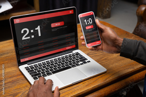 Foto Close up laptop and smartphone screen with mobile app for betting and score