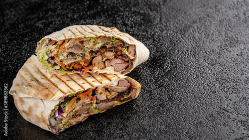 Turkish oriental cuisine. Grilled kebab with lamb, tomatoes, carrots, wrapped in thin pita bread.