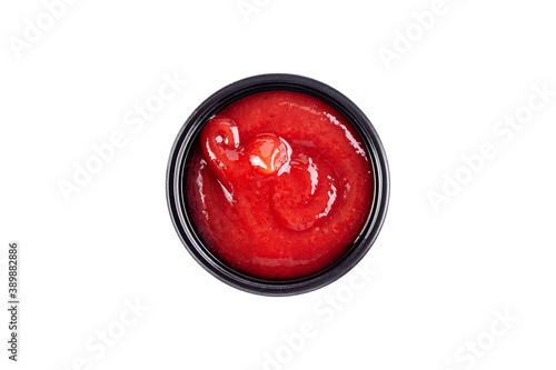 Sauce homemade ketchup in a plastic disposable dish on a white background, top view. Isolated