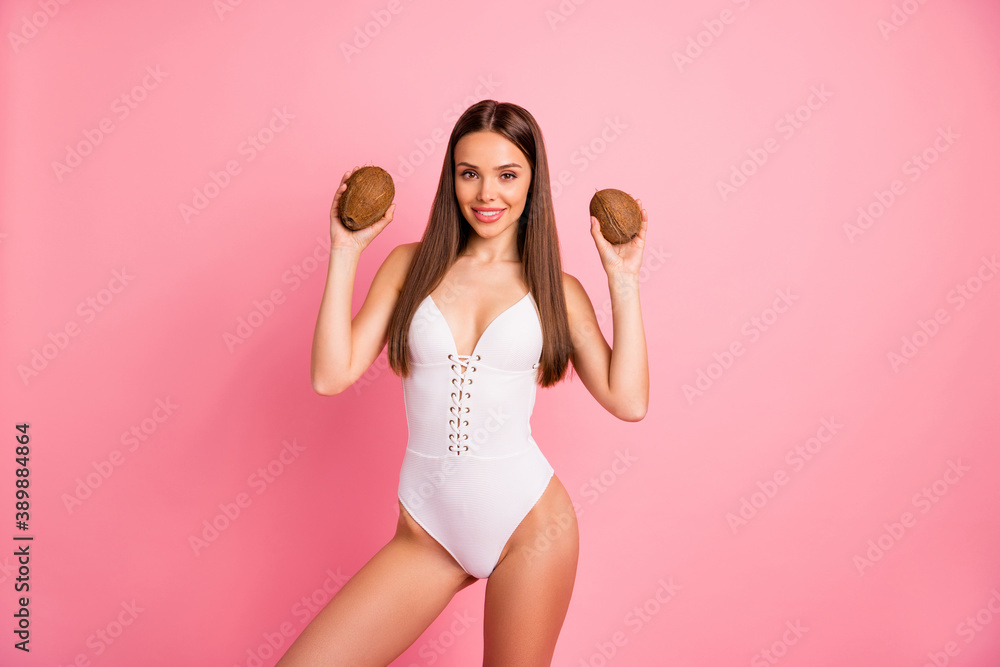 Portrait of nice-looking attractive lovely stunning cheerful cheery positive sporty fit thin straight-haired lady holding in hands two coconuts isolated on pink pastel background Portrait of nice-looking attractive lovely stunning cheerful cheery positive sporty fit thin straight-haired lady holding in hands two coconuts isolated on pink pastel background