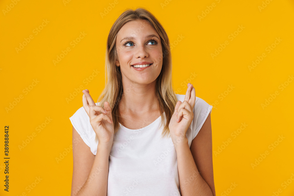 Happy beautiful girl posing with fingers crossed for good luck Happy beautiful girl posing with fingers crossed for good luck