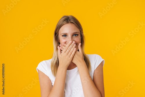 Cheerful beautiful girl posing and covering her mouth