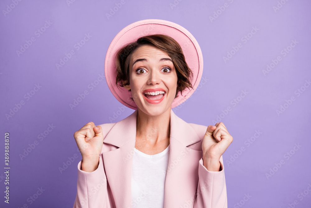 Photo of curly lucky lovely woman wear pink vintage blazer cap arms fists isolated violet color background Photo of curly lucky lovely woman wear pink vintage blazer cap arms fists isolated violet color background