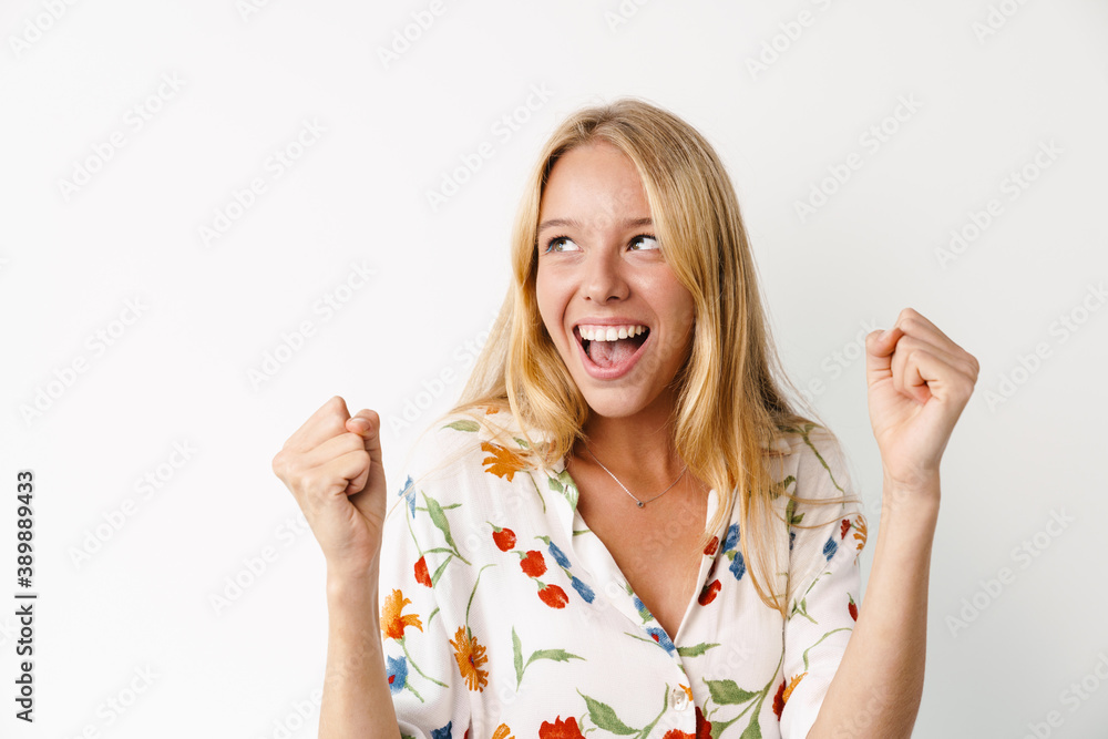 Excited beautiful girl making winner gesture and exclaiming