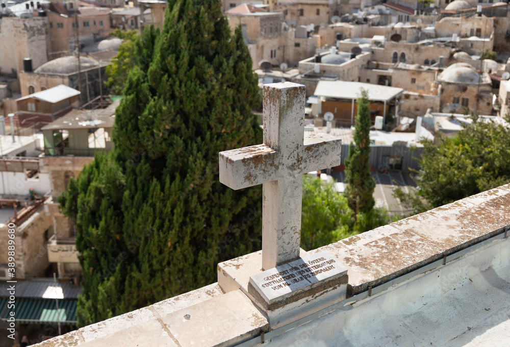A large  stone cross stands on the roof of the Austrian Hospice building in the old city of Jerusalem in Israel