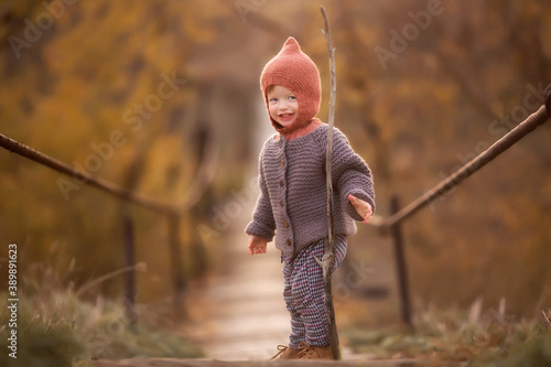 little boy on the bridge over the river in autumn photo shoot
