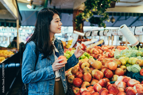 Fotografie portrait beautiful lady holding apples is looking at the fresh fruits with smile
