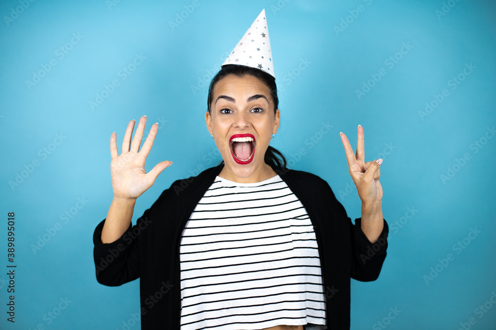 Εκτύπωση καμβά Young beautiful woman wearing a birthday hat over insolated blue background show