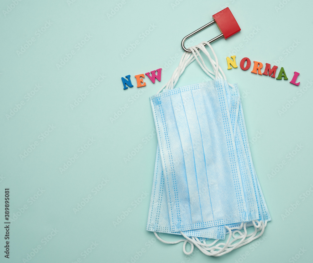 stack of disposable masks and a metal lock on a blue background stack of disposable masks and a metal lock on a blue background