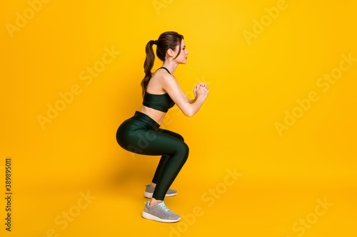 Full length body size profile side view of her she nice attractive focused slender girl doing sit-ups isolated over bright yellow color background