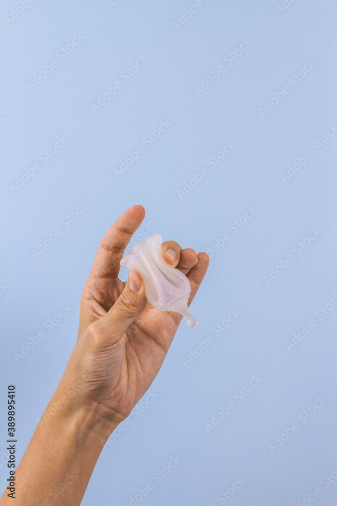 Woman hands holding menstrual cup on pastel blue background. Zero waste alternatives, hygiene period product. Copy spase Woman hands holding menstrual cup on pastel blue background. Zero waste alternatives, hygiene period product. Copy spase