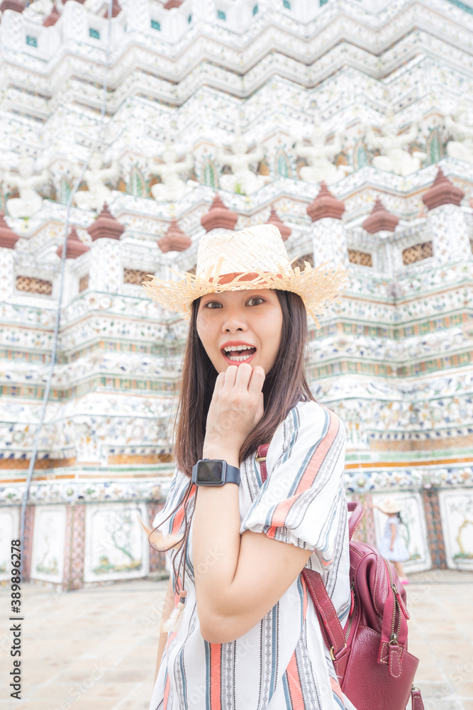Asian girl tourist smiling while visiting Wat Arun or Temple of Dawn backpacker women