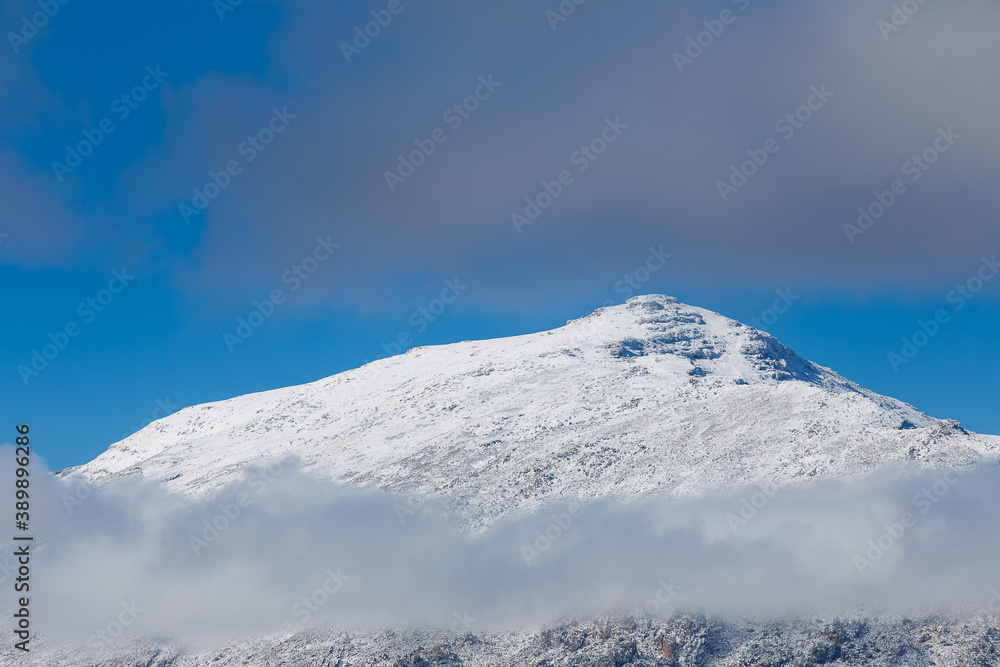 Close up view of a snow covered Matroosberg Mountain peeking out through the clouds near Ceres in the Western Cape of South Africa Close up view of a snow covered Matroosberg Mountain peeking out through the clouds near Ceres in the Western Cape of South Africa