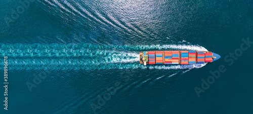 Fotografie, Obraz Aerial top view of cargo ship with contrail in the ocean sea ship carrying conta