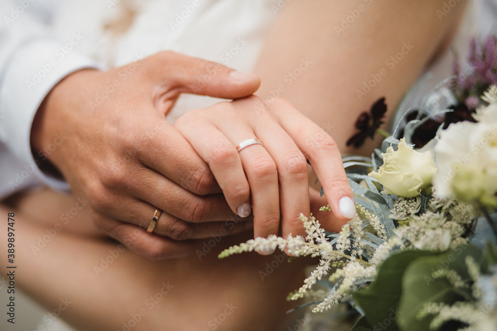 close-up of a young married couple, wedding rings on the hands of the newlyweds, in the frame part of the wedding bouquet
close-up of a young married couple, wedding rings on the hands of the newlyweds, in the frame part of the wedding bouquet