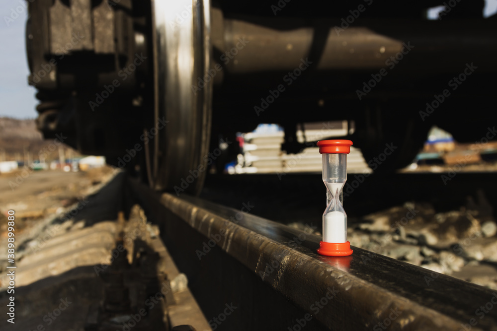 Railway freight cars on rails with hourglass, the concept of saving time on railway transportation. Railway freight cars on rails with hourglass, the concept of saving time on railway transportation.