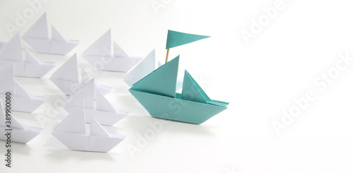 blue paper ship with small boats.Leadership concept.