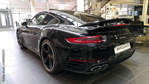 Moscow. February 2018. Black Porsche 911 991 Carrera at dealer showroom. Taillights and aerodynamic spoiler. Back and side view