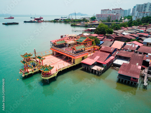 Penang island tourist attraction in Malaysia: temple and houses on the water (jetties clan) photographed from a drone.