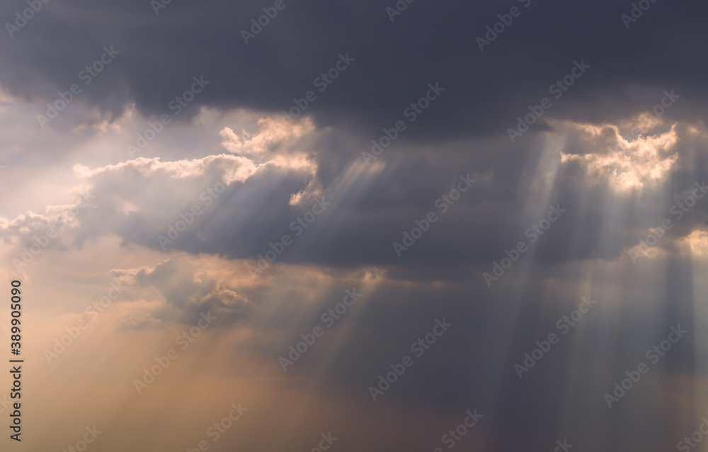 The sun's rays passing through the clouds and shining form an interesting light pattern against the sky. Copy space. Selective focus.