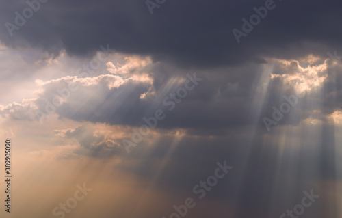 The sun's rays passing through the clouds and shining form an interesting light pattern against the sky. Copy space. Selective focus. © num