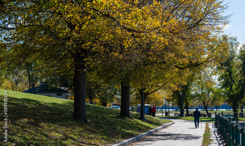 Old man walking with cane in distance during fall day. photo