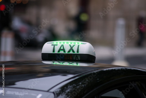Closeup of taxi sign on the roof of car parked in the street