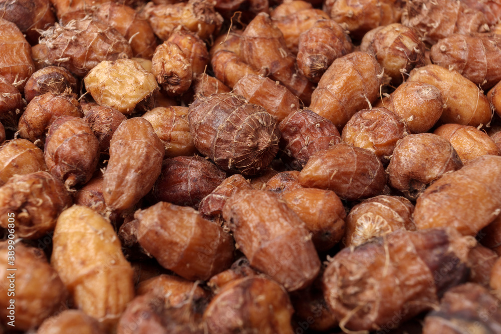 Side view of pile of raw tiger nuts or chufa as background, close up. Side view of pile of raw tiger nuts or chufa as background, close up.