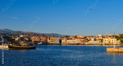 Beautiful view of Old Venetian harbour of Chania, Crete, Greece, quayside, tourist boats by piers in early morning. Cretan mountains in background.