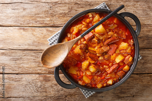 Locro stew of squash, beans, corn, potatoes, sausages and meat close-up in a pot on the table. horizontal top view from above photo