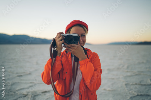 Positive female tourist with photo camera in Death Valley