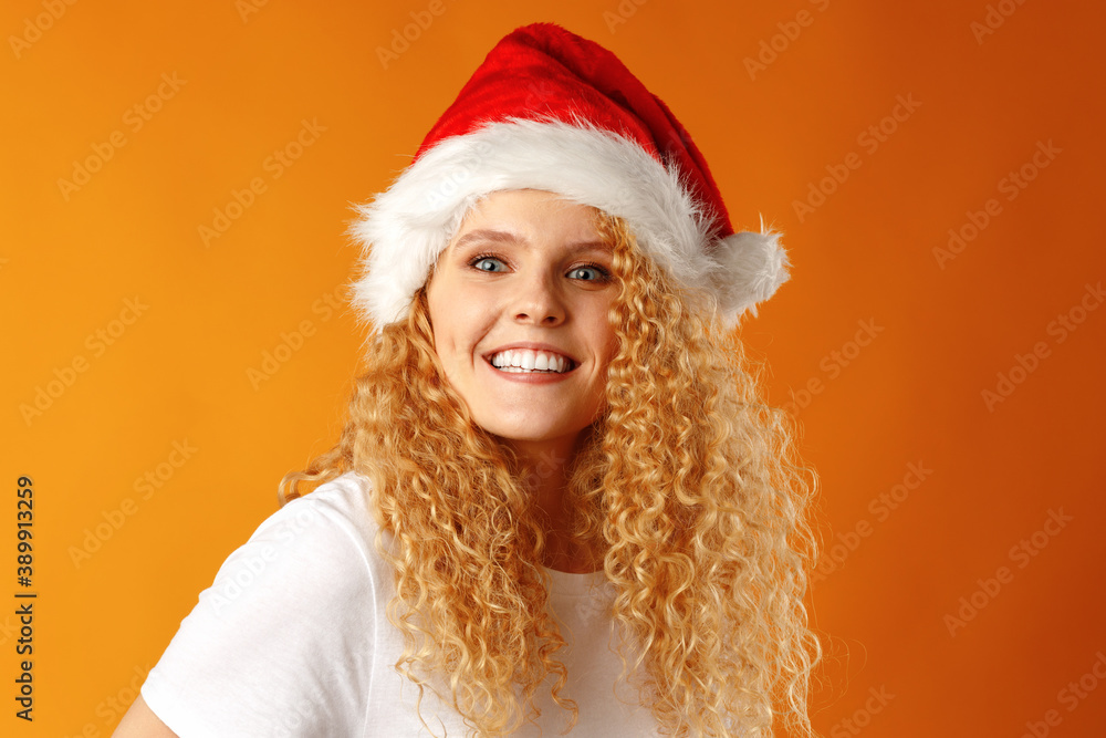 Cheerful young blonde curly woman wearing Santa hat Cheerful young blonde curly woman wearing Santa hat