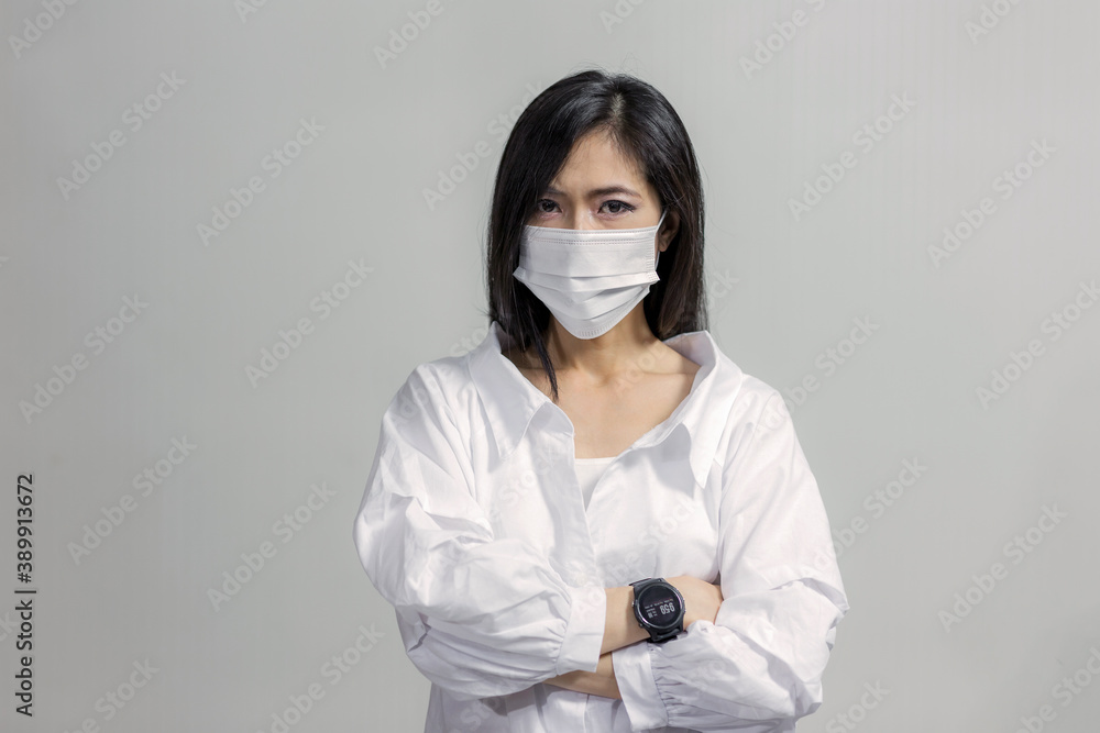 Portrait of Asian woman wearing white medical face mask isolated on gray background Portrait of Asian woman wearing white medical face mask isolated on gray background